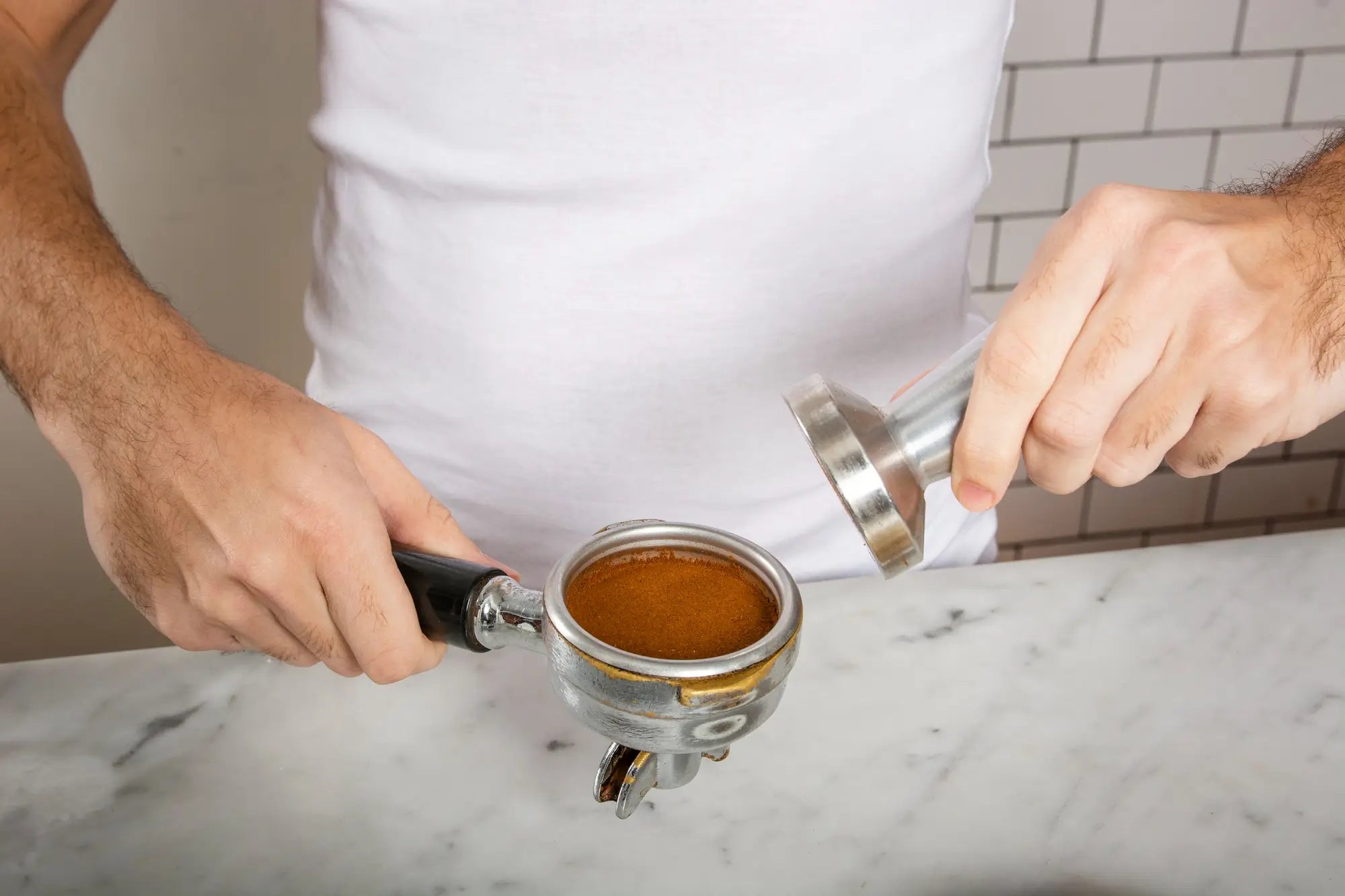 man using tamper to make coffee